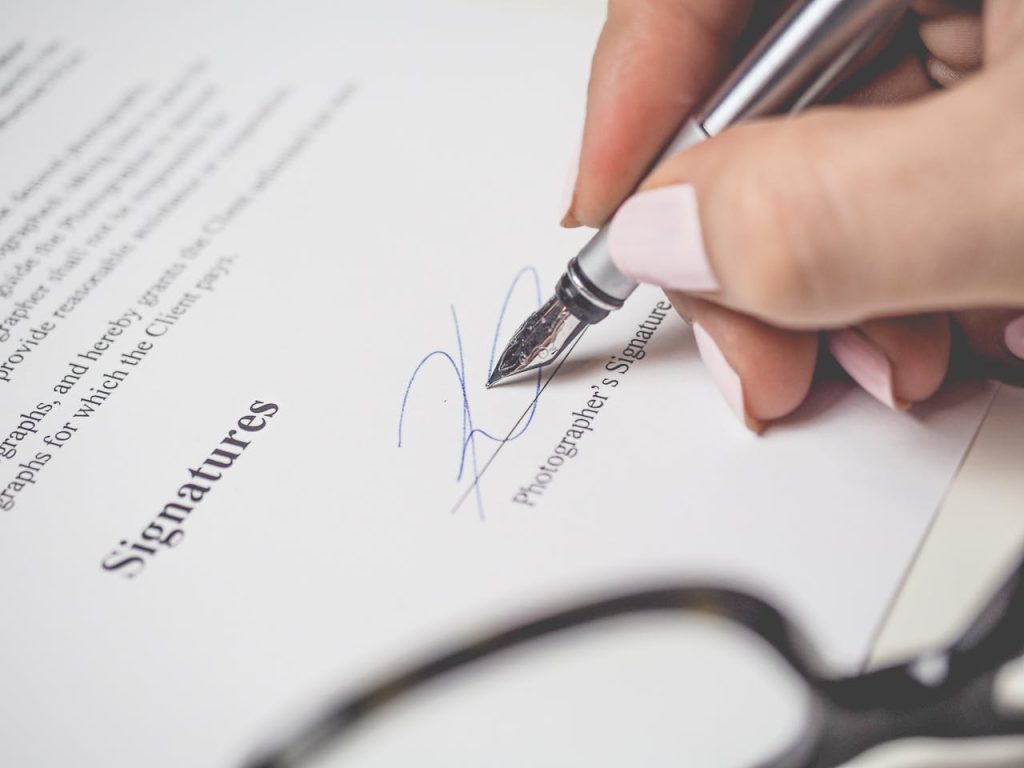 Hand signing a document with a fountain pen