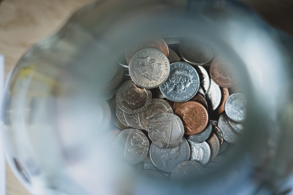Top-down view of a jar full of UK coins
