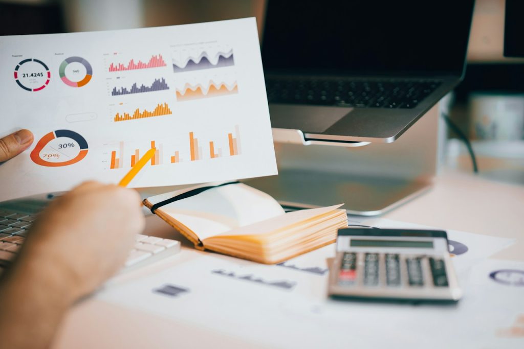 Person holding a piece of paper showing various graphs